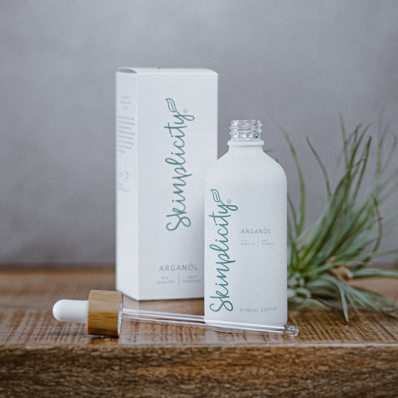 Bio Arganöl für Haut und Gesicht mit Pipette auf Holzuntergrund