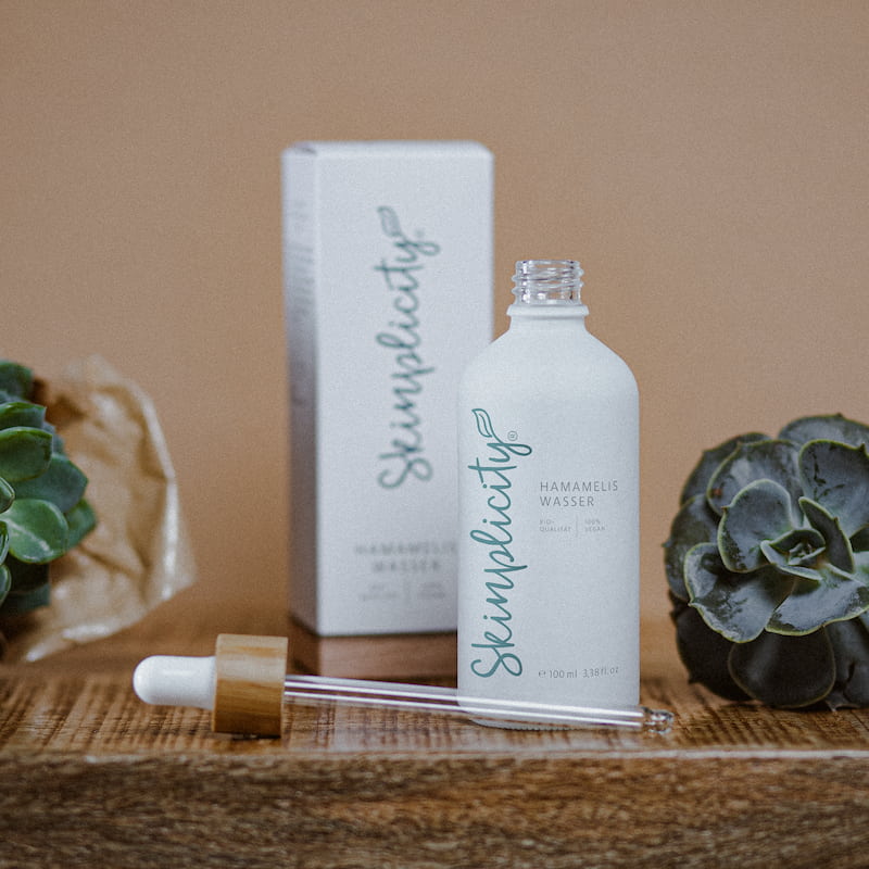 Hamameliswasser im Fläschchen mir Pipette auf Holzuntergrund